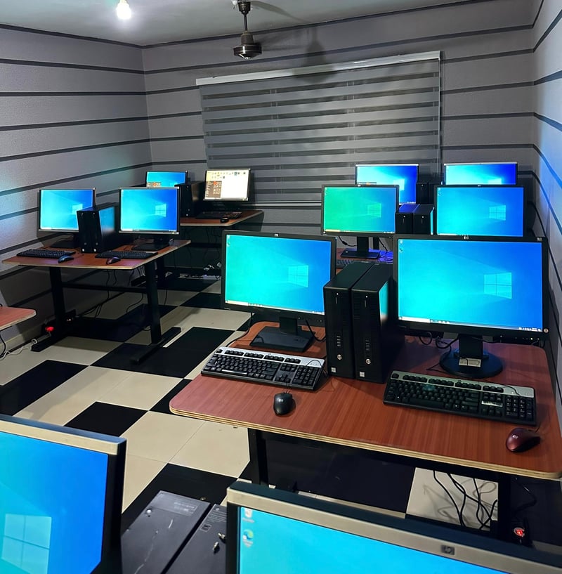 Computer lab with rows of desktop computers on wooden desks, set up for technical skills training.